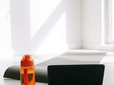 Yoga mat and a water bottle on a dark floor.